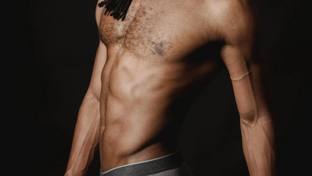 Close-up shot of a mans abdomen after recovering from a tummy tuck surgery
