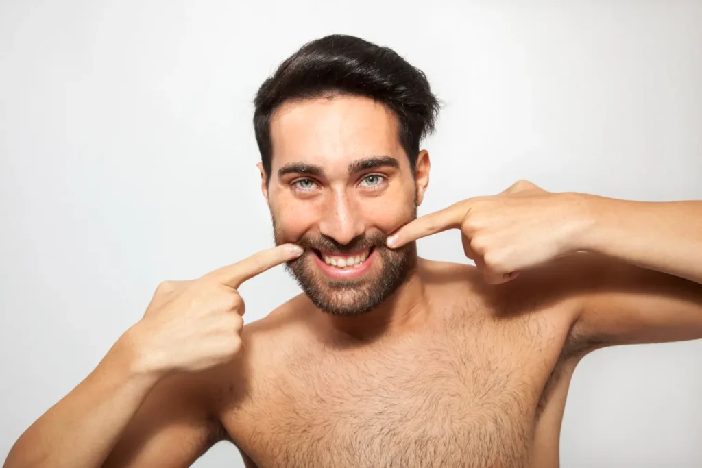 Man pointing to his face and thinking of getting jawline fillers