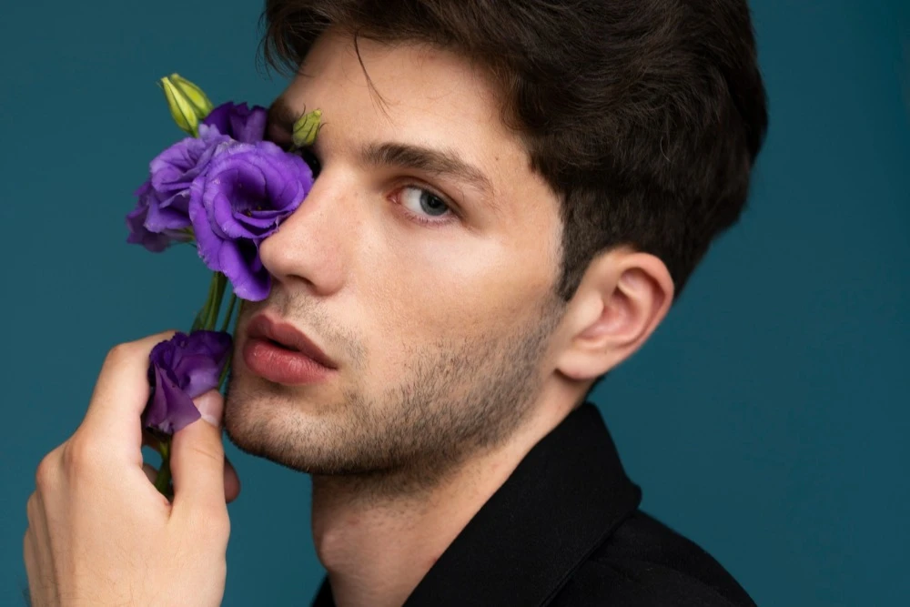 Man with flowers near face after undergoing skin tightening plastic surgery