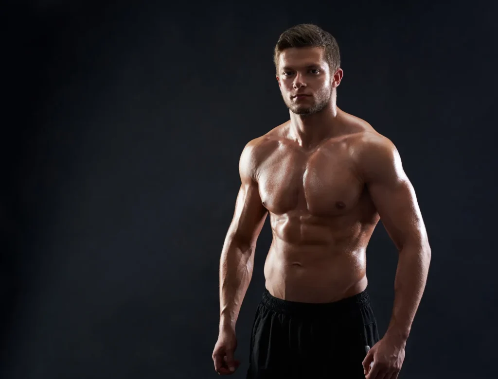 Shirtless man flexing his abs after getting liposuction for abdomen
