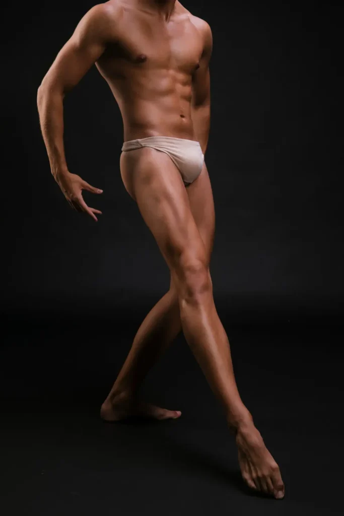 A lean, muscular physique showcasing sculpted abs and toned, lifted lower body legs in a graceful dynamic pose