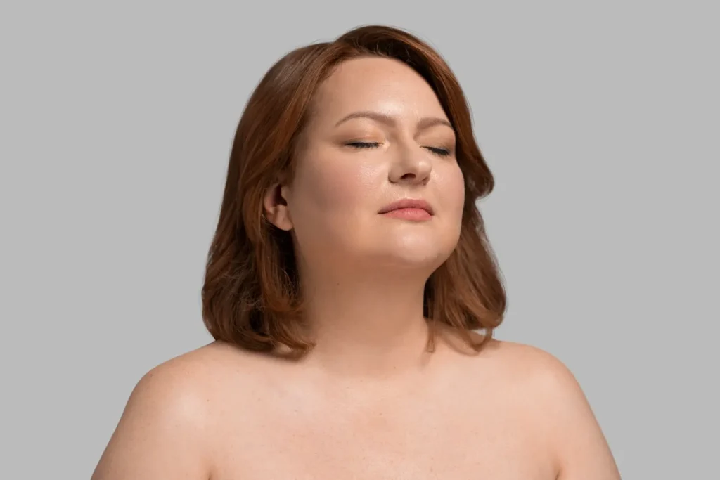 A woman with shoulder-length auburn hair and closed eyes