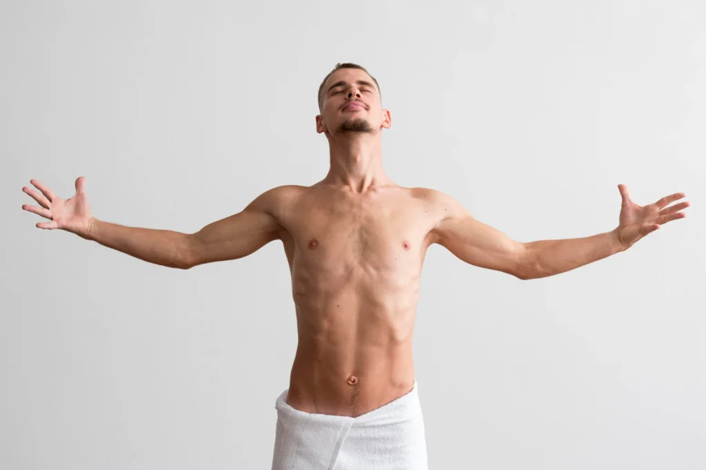 Man with arms outstretched displaying body contours and neck area for plastic surgery assessment