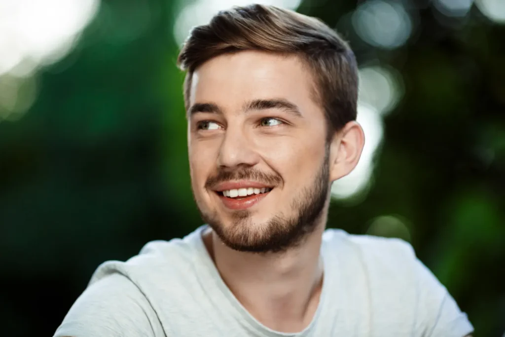 Man with defined jawline smiling after following proper FaceTite post-treatment care