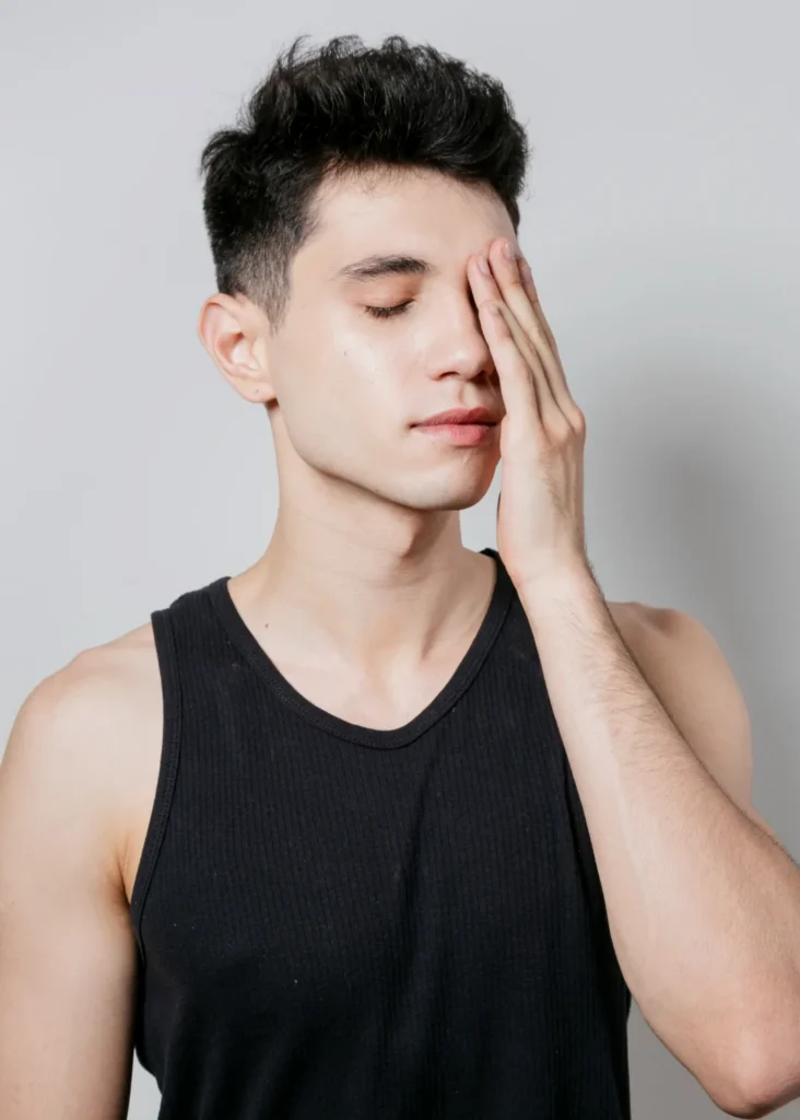 Man with hand on face showcasing slim jawline and facial structure for face slimming botox