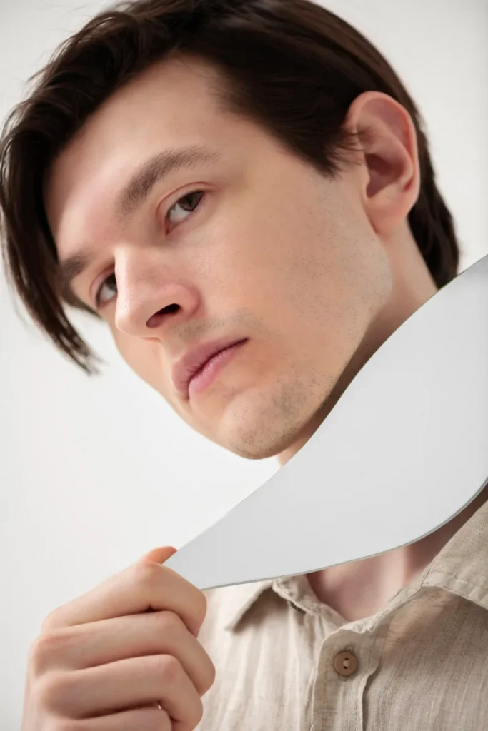 Side view man posing with mirror piece
