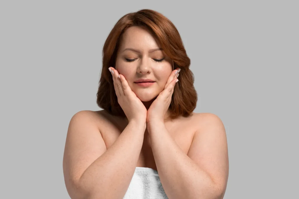 Woman with both palms on her face thinking of getting FaceTite to remove her facial fat