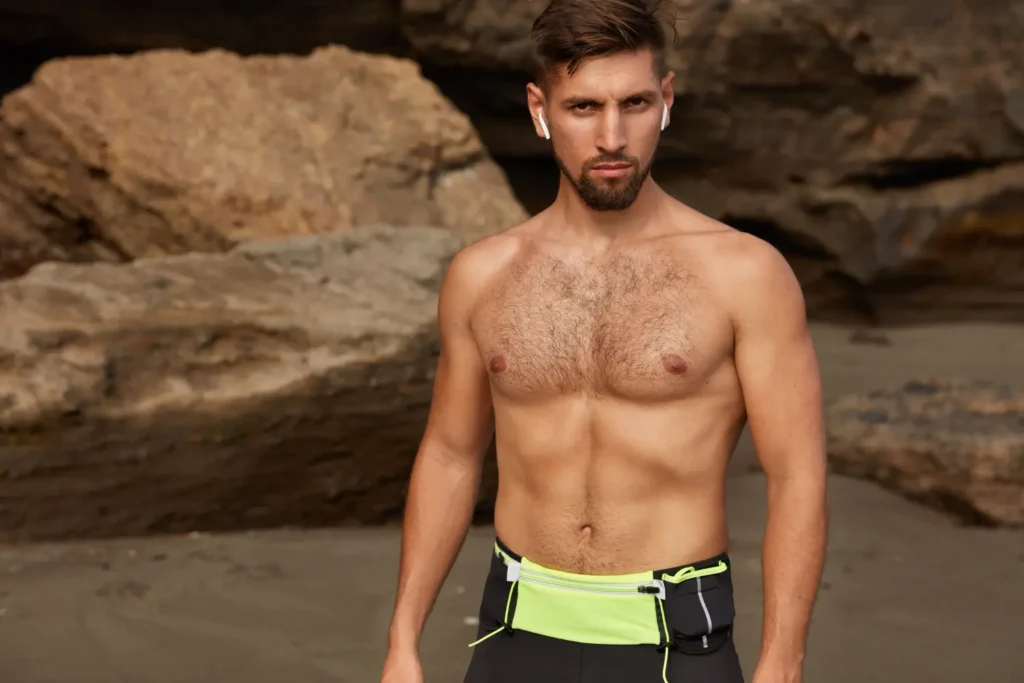 Man showing his sculpted abs outside after tummy tuck recovery