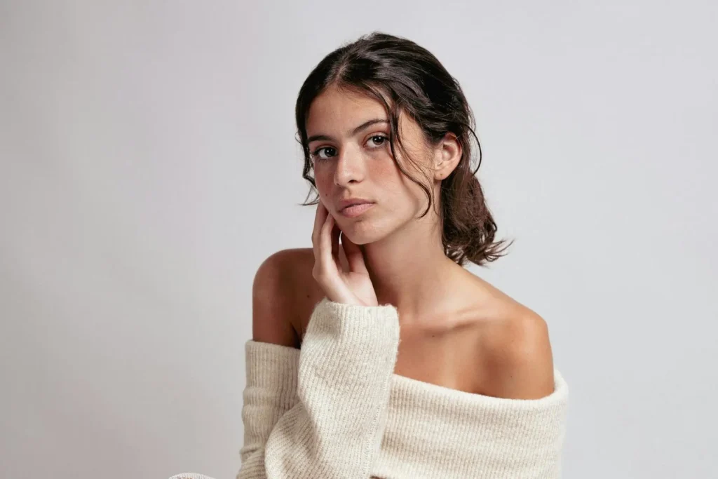 Woman touching her chin and showing off defined neck and chin after getting neck liposuction