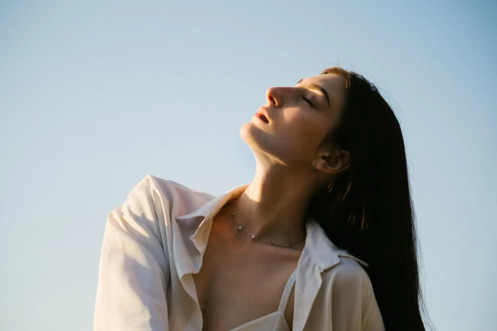 Woman looking up and flexing her neck and chin after recovering from neck lipo