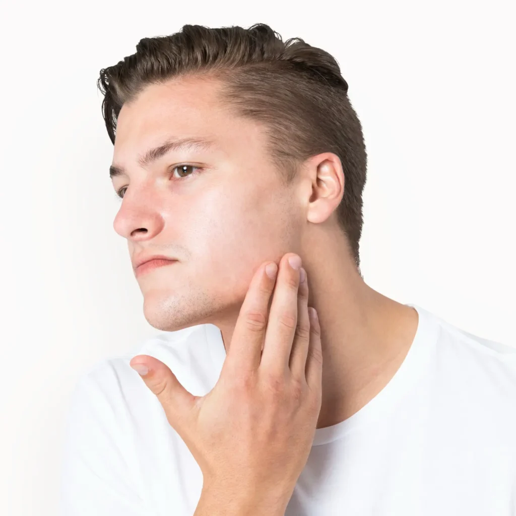 Man touching his jawline to examine facial contour before jawline filler treatment