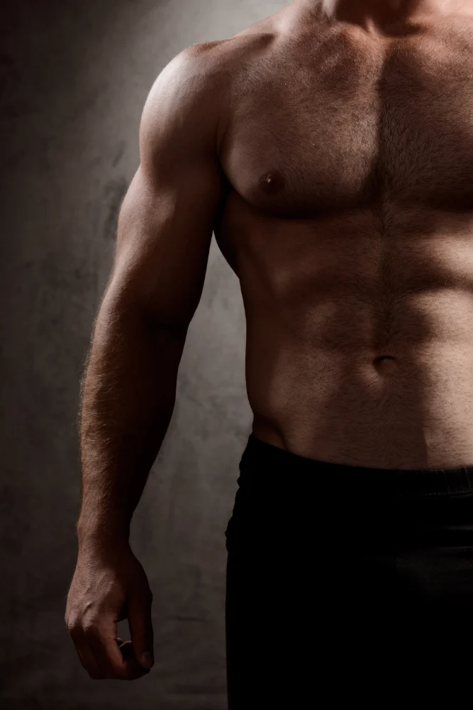 Sportive man body over dark wall