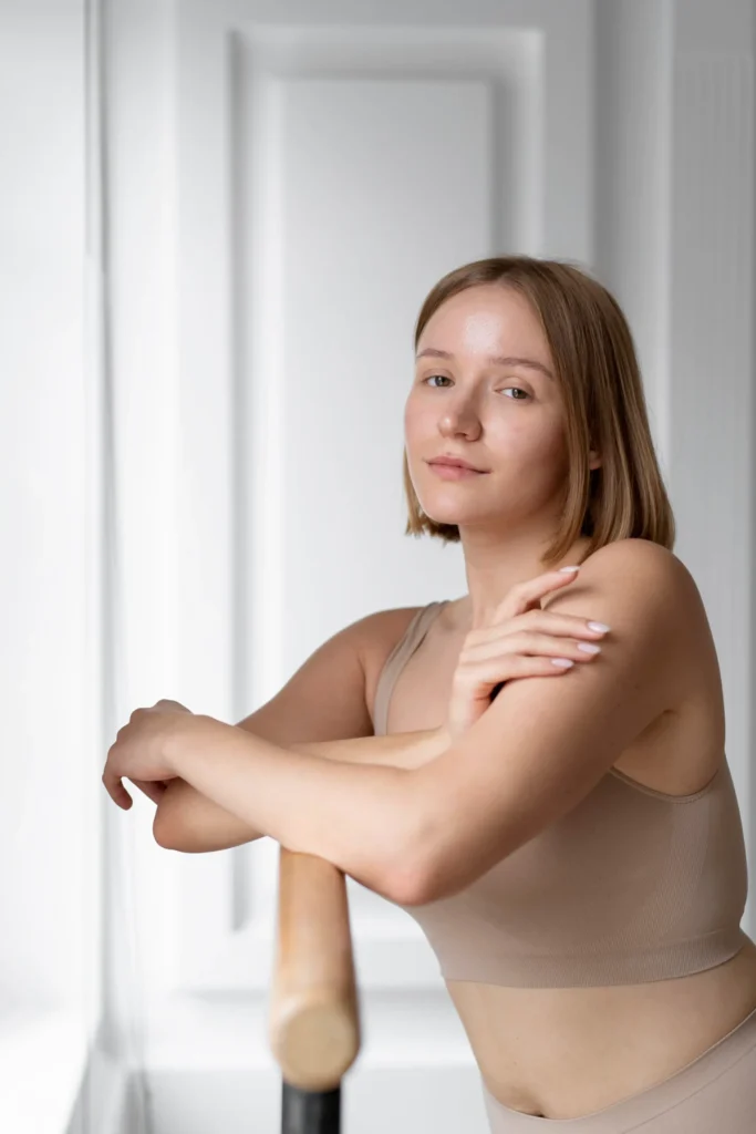 Used to success. Happy young woman in casual wear gesturing and keeping eyes closed while standing against grey wall