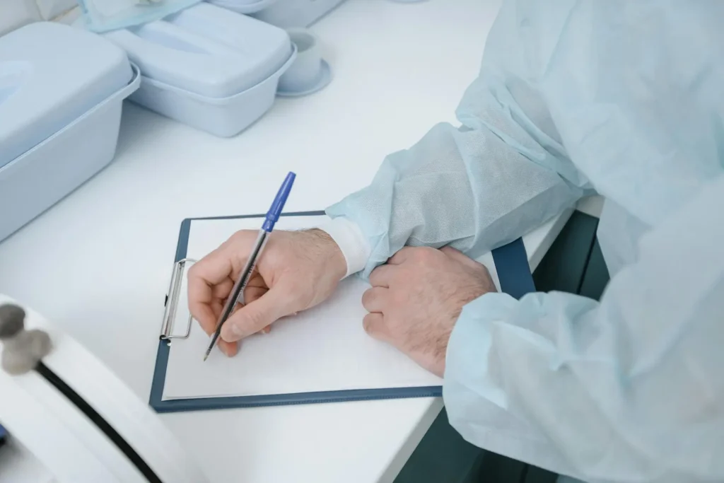 Close-up shot of a plastic surgeon writing essentials after a liposuction surgery