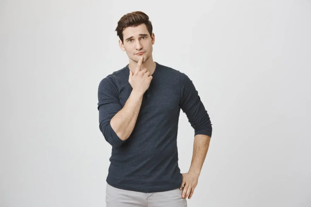 A young man in a long-sleeved shirt looking curious and thoughtful, posing the question of what individual factors