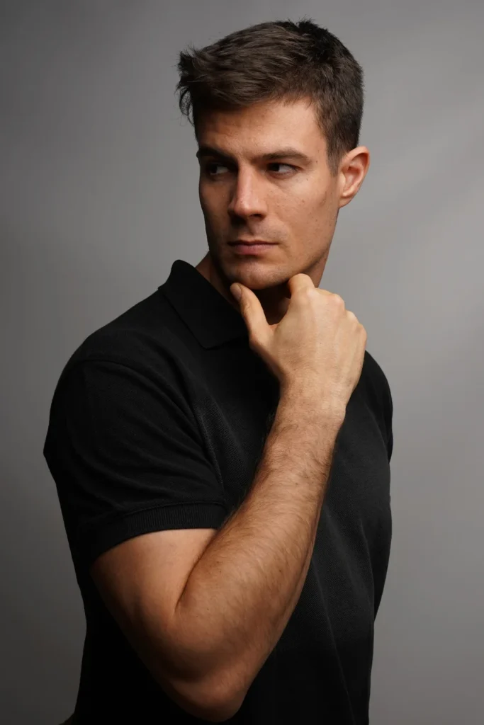 Vertical shot of a handsome man holding his chin