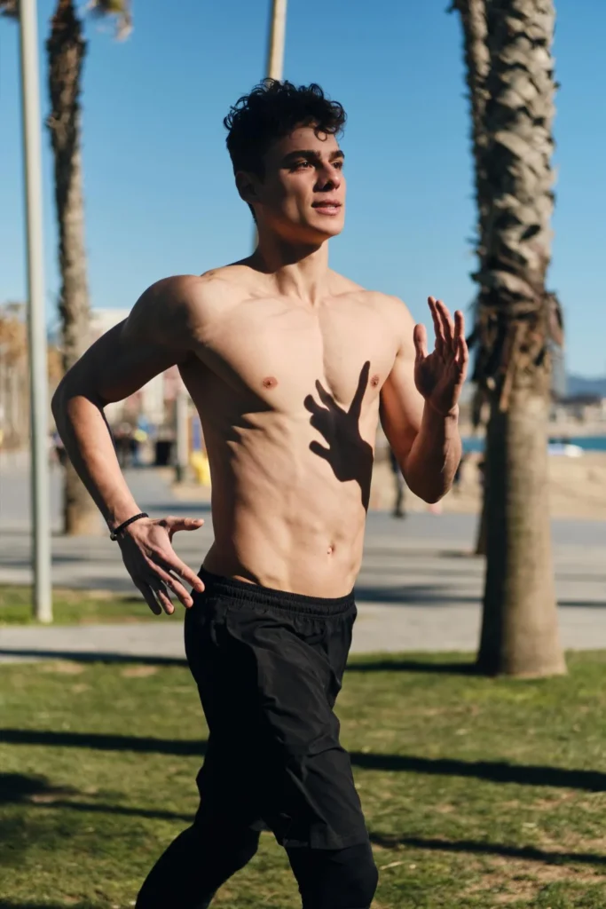 Young attractive sporty man jogging through streets