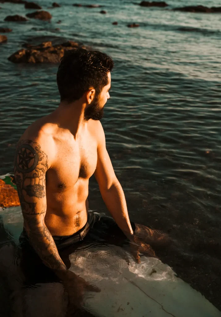 Young man sitting on surfboard in sea water