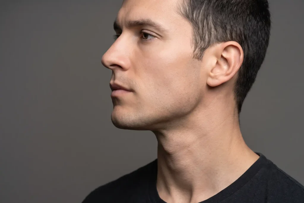 Close-up of a sharp male jawline and neck contour after liposuction