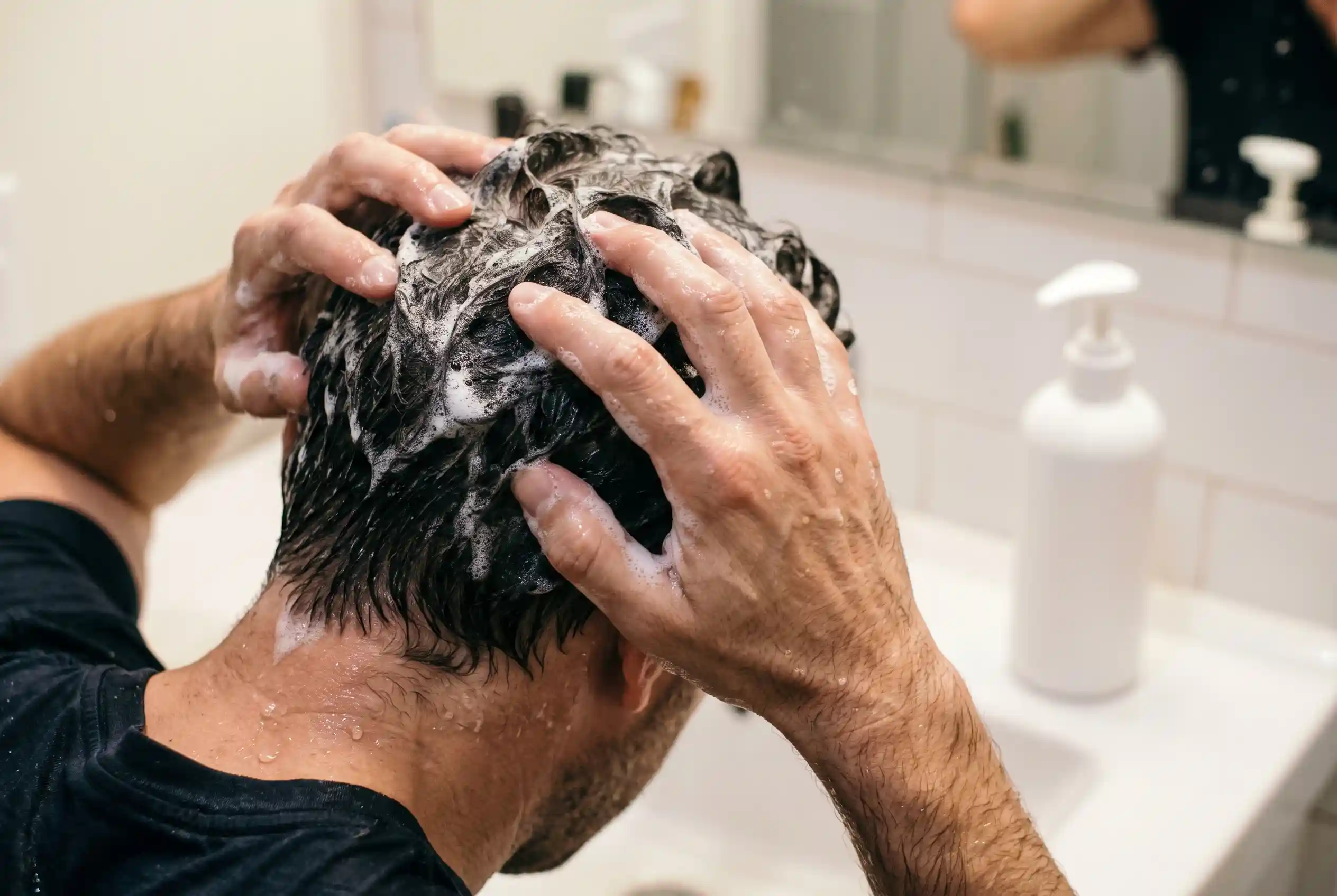 Man washing his scalp with fingertips using a fragrance-free cleanser after a PRP hair session