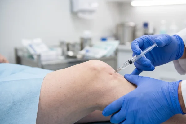 Clinician giving a PRP injection into a patient's knee for joint pain relief