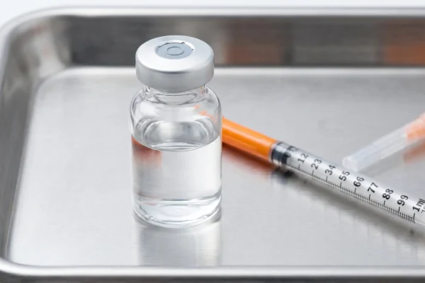Close-up of a peptide vial and syringe used in tesamorelin therapy