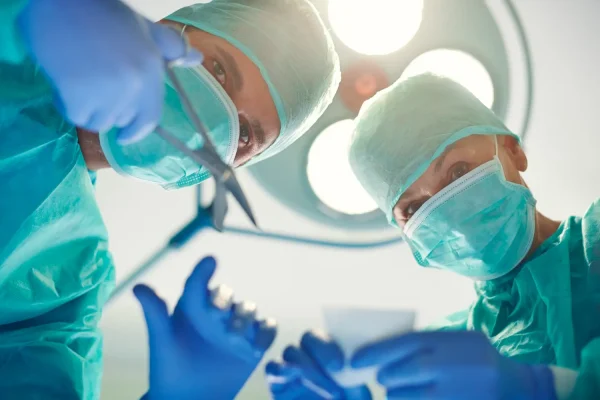 Close up shot of plastic surgeons performing a tummy tuck surgery