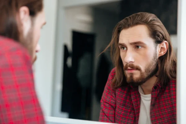 Man checking his face and skin to see if his Melanotan peptide therapy worked