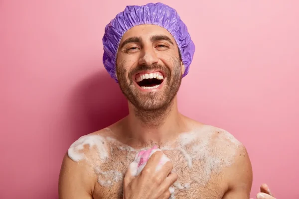 Man scrubbing soap on his body and taking a full bath after tummy tuck recovery