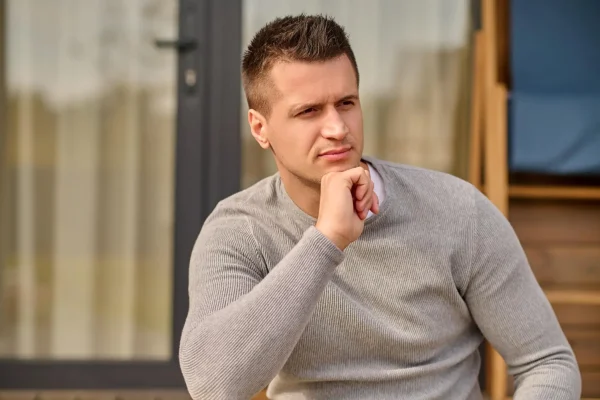 Man thinking about what to after noticing signs of infection after undergoing liposuction