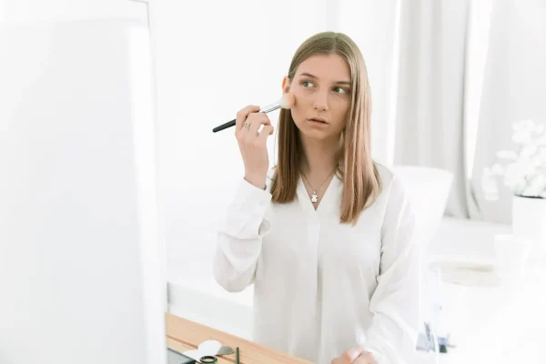 Woman applying blush before Botox appointment