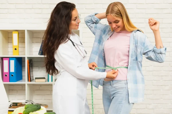 Woman getting assessed by a cosmetic surgeon for body contouring after massive weight loss