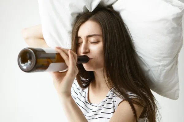 Woman holding a pillow and a bottle of alcohol before Botox