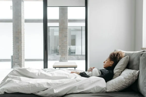 Woman resting in bed after liposuction surgery