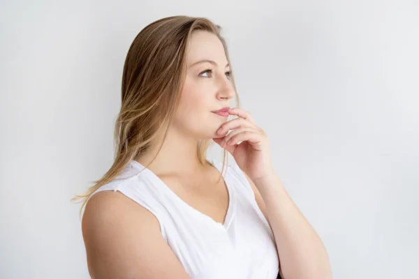 Woman touching her double chin and thinking of getting a non surgical treatment for it