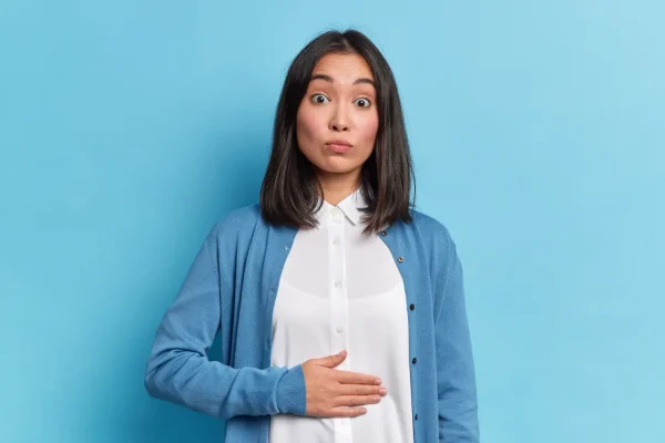 Woman wearing a white blouse and blue cardigan experiencing bad HD lipo result