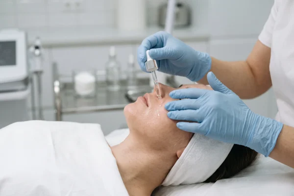 Clinician applying copper peptide serum during recovery care at a medical clinic