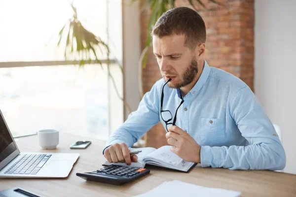 Man calculating the total cost he may need to prepare for a plastic surgery