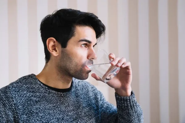 Man drinking plenty of water before PRP hair treatment