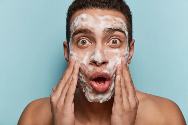 Man looking shocked while washing his face after Botox treatment