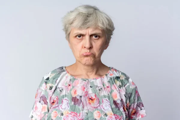 Senior woman looking sad about nasolabial fold filler gone wrong