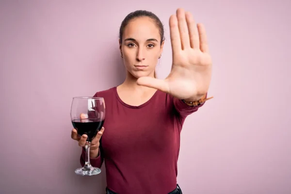 Woman motioning to stop drinking alcohol before and after PDO thread lift procedure