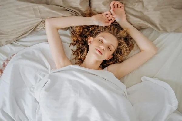 Woman sleeping in bed and recovering from her lipo surgery