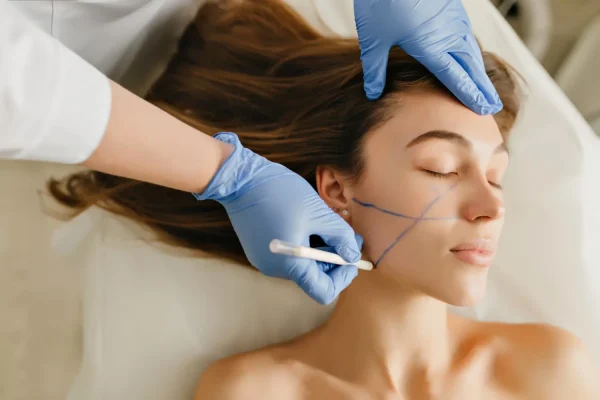 Cosmetic surgeon marking patients chin before procedure