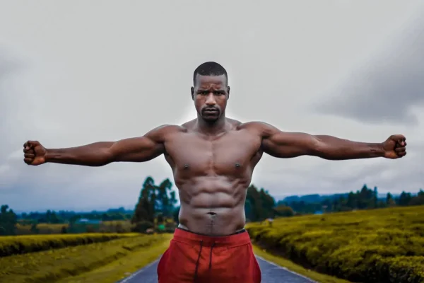 Man flexing his toned body outside after recovering from his high definition liposuction surgery