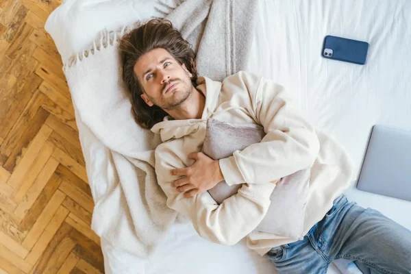 Man hugging a pillow and is resting after liposuction procedure