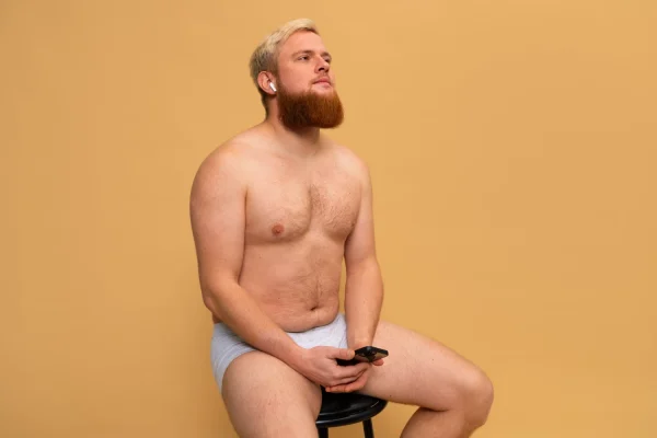 Man in underwear thinking if tummy tuck is worth it