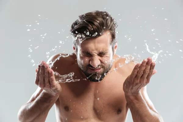 Man splashing face with water to avoid getting his tummy tuck incisions