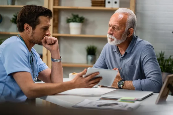 Plastic surgeon discussing Melanotan peptide therapy to a senior man