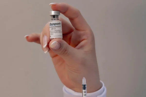 Plastic surgeon holding a Botox vial and a syringe